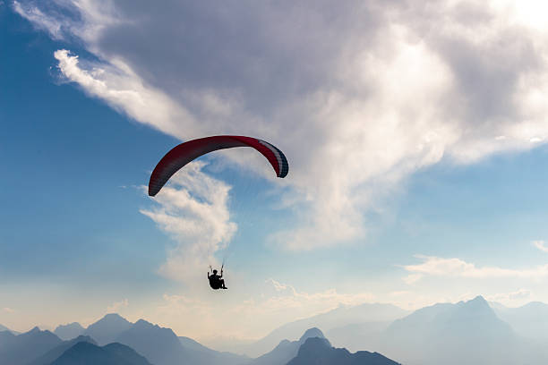 istock Parachute and human silhouette. Blu sky adventure. 605768992