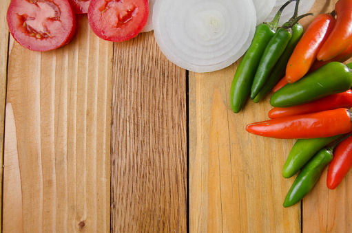 Serrano pepper , tomato and onion on wood background