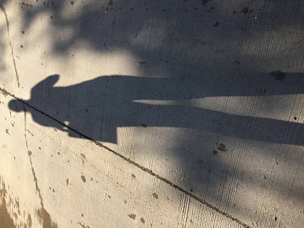 istock Woman shadow on concrete road 605771746