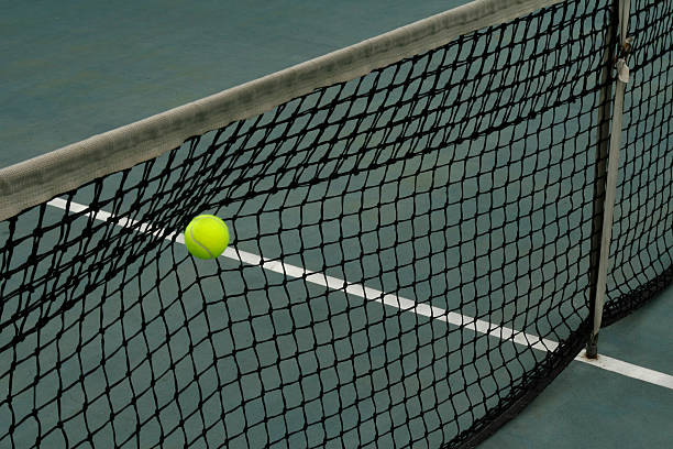 istock Tennis ball caught in the net 605772818