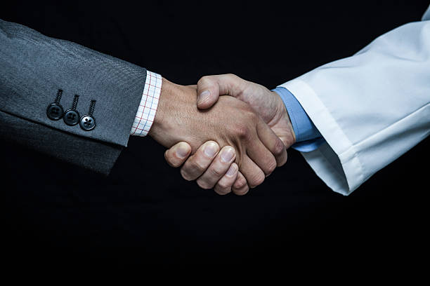 istock Doctor shaking hands and business people's hand 605773816