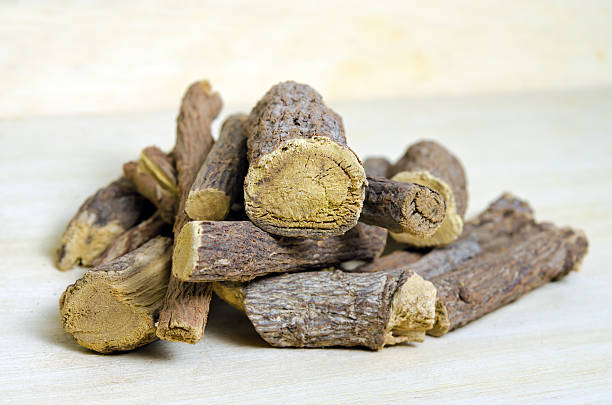 istock Licorice or liquorice root sticks isolated on wood background 605775330