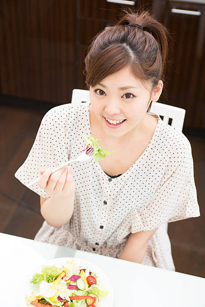 istock young attractive asian woman who  eats 605776548
