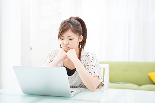 istock young asian woman using laptop in the dining room,think 605778090