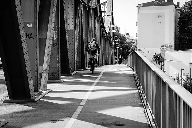 istock Rear View Of Man Riding Bicycle On Bridge 605781309