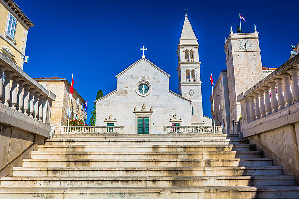 Supetar cathedral island Brac. View at mediterranean architecture with cathedral in background, town Supetar, popular touristic destination, on Adriatic Sea, Island Brac, Croatia. old catholic church on island brac croatia stock pictures, royalty-free photos & images