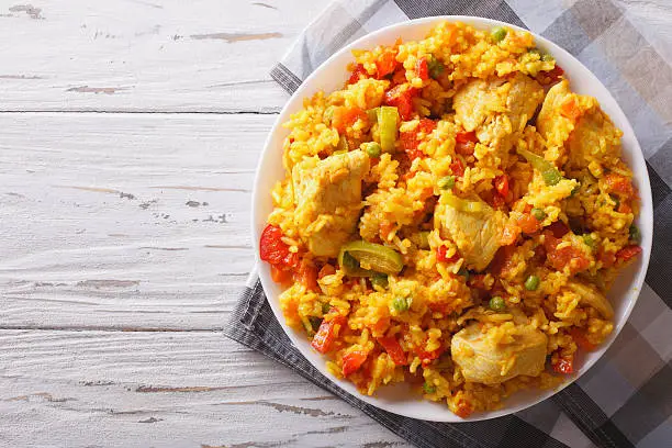 Hispanic cuisine: Arroz con pollo close up in a bowl on the table. horizontal top view