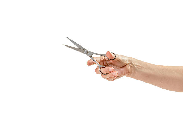 istock Woman hand is holding scissors isolated on white 605785148