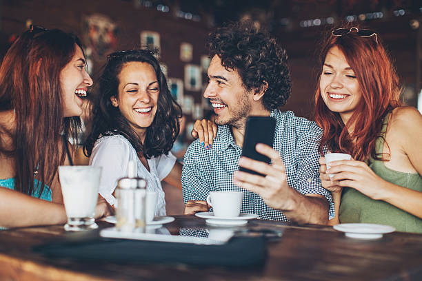istock One man with three women in cafe 605785652