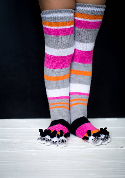 istock Baby feet in warm, long multicolored socks with toes 605785960