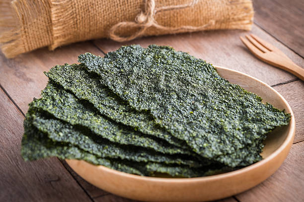 Crispy dried seaweed on wooden plate Crispy dried seaweed on wooden plate nori stock pictures, royalty-free photos & images