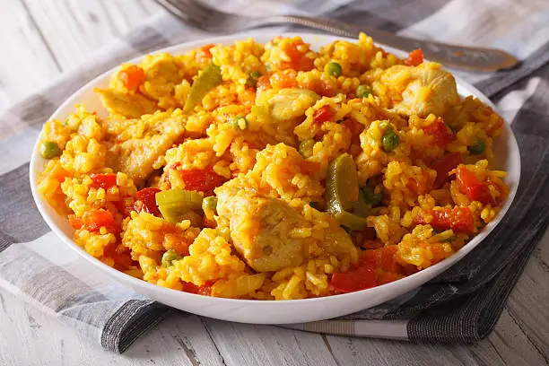 Hispanic cuisine: Arroz con pollo - rice with chicken close up in a bowl on the table. Horizontal