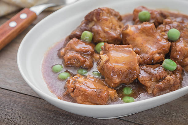 istock Braised pork ribs with green peas in bowl 605787112