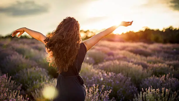 Young woman with arms out in lavender in lavender field