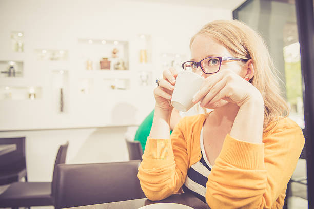 hora da manhã, mulher loira tomando café no bar - caffeine caucasian satisfaction small business - fotografias e filmes do acervo