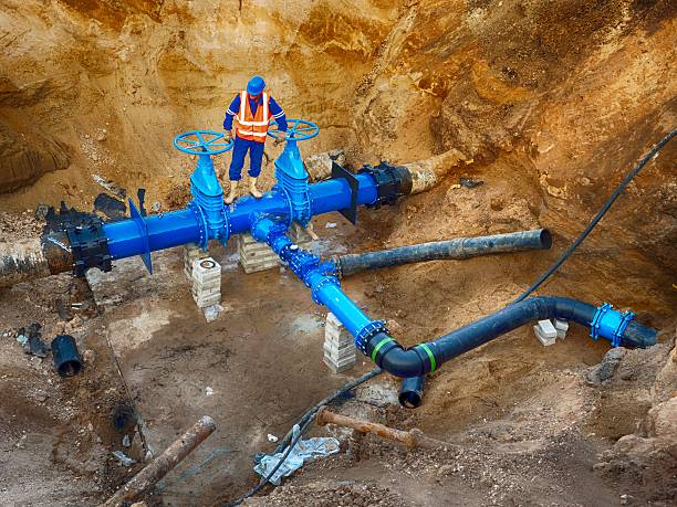Worker underground on gate valve, reconstrucion of drink water system stock photo