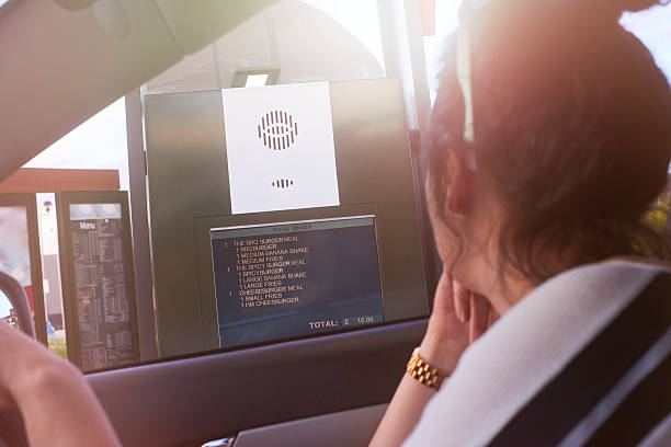 Ordering at the drive through A car pulls up to the ordering point at a fast food restaurant drive through. drive through photos stock pictures, royalty-free photos & images