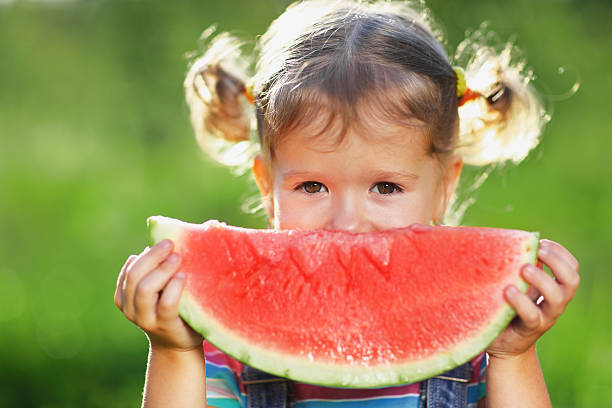 istock Happy child girl eats watermelon 605974026