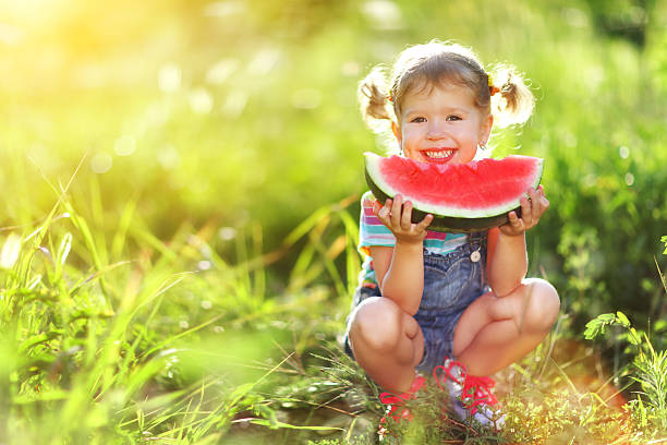 istock Happy child girl eats watermelon 605974290