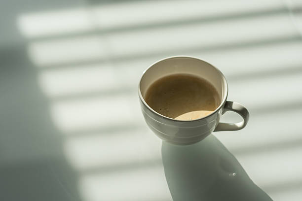 istock Cup of coffee on the white glass table. 605976238