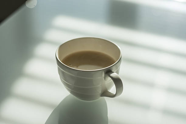 istock Cup of coffee on the white glass table. 605976726