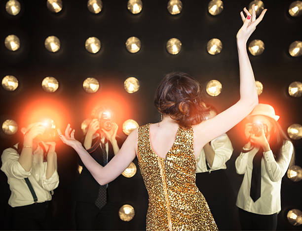 istock Superstar woman posing to paparazzi 605980602