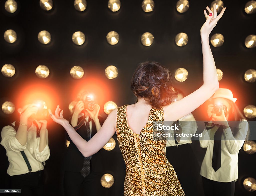 Superstar woman posing to paparazzi Superstar woman wearing golden shining dress posing to paparazzi Celebrities Stock Photo