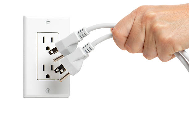 женщина отключая электрические шнуры на белом - electric plug outlet pulling electricity стоковые фото и изображения