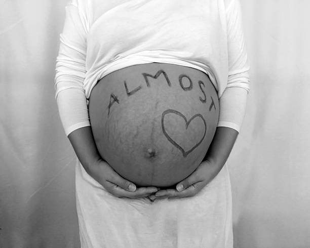 istock Mom's hands around pregnant belly 605983438