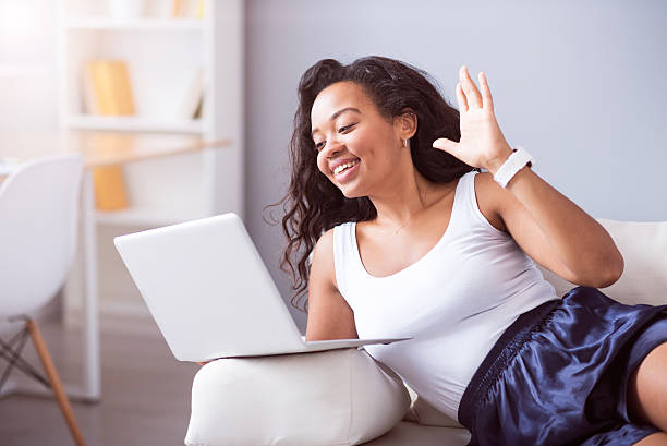 istock Joyful young woman talking through the Internet 605983956