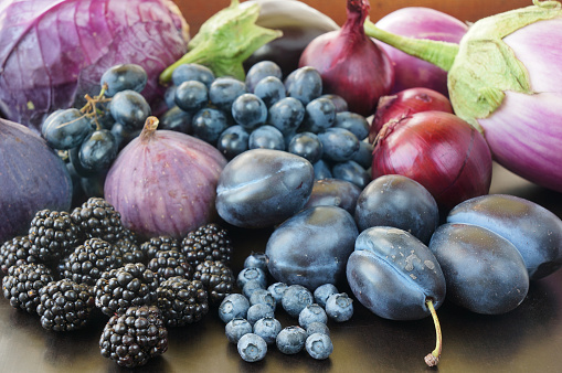 Blue and purple food. Berries, fruits and vegetables on a black background.