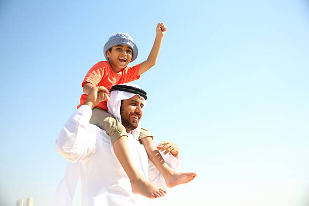 Father and Son Arabian family playing in the beach. middle eastern culture stock pictures, royalty-free photos & images