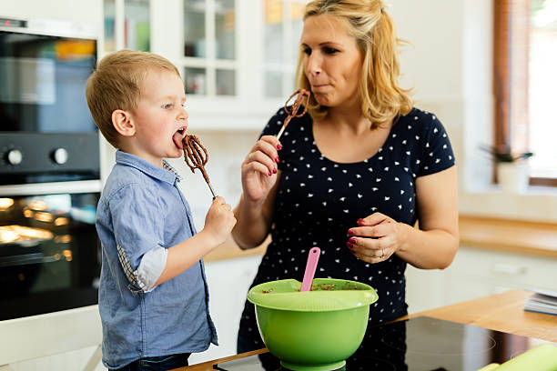 istock Child helping mother make muffins 605987486