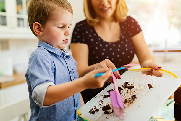 istock Smart cute child helping mother in kitchen 605987626