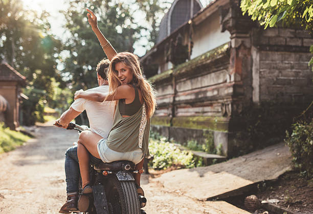 Couple enjoying motorcycle ride on village road