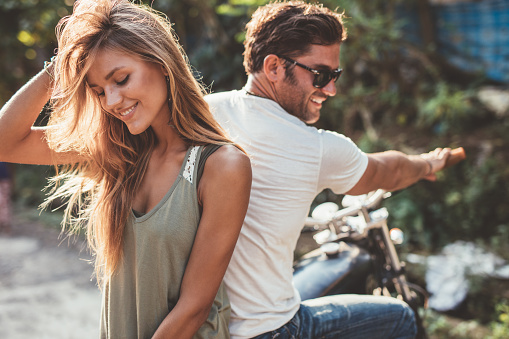 Portrait of beautiful young couple on a motorcycle. Attractive young woman with handsome young man on motorbike.