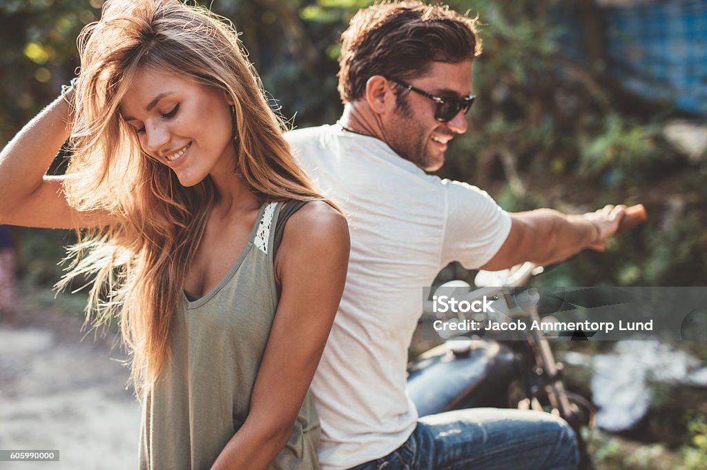 Beautiful young couple on a motorcycle Portrait of beautiful young couple on a motorcycle. Attractive young woman with handsome young man on motorbike. Couple - Relationship Stock Photo