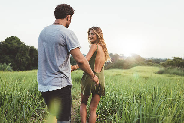 istock Young couple walking along country path 605990462
