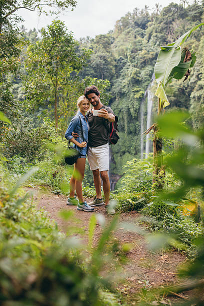 istock Loving young couple in forest taking self portrait 605990606
