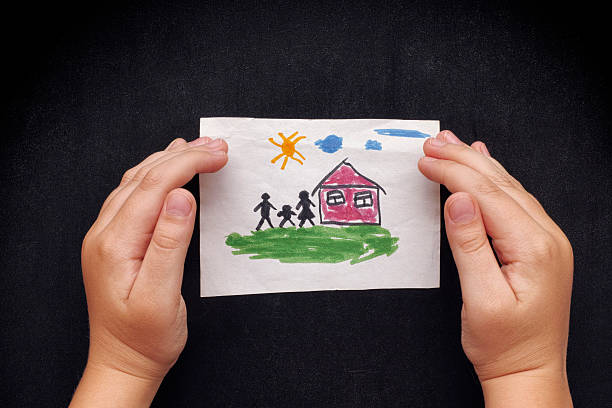 istock Child protects a drawn house with family 605990794
