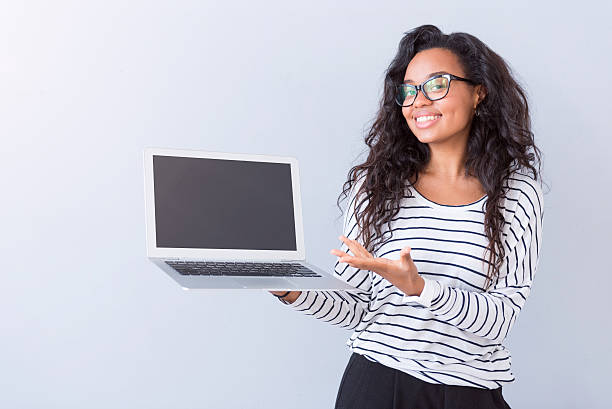 istock Cheerful woman holding laptop 605992042
