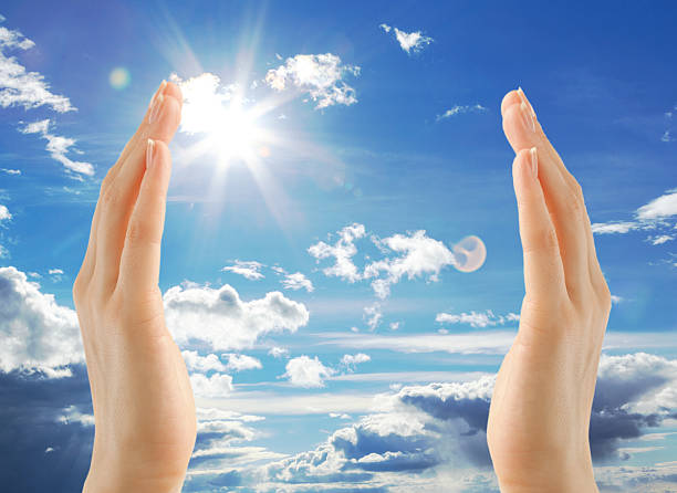 istock Female hands on blue sky background 605992334