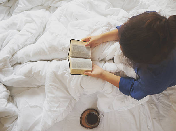 istock Girl reading book and drinking coffee on the bed 605993736
