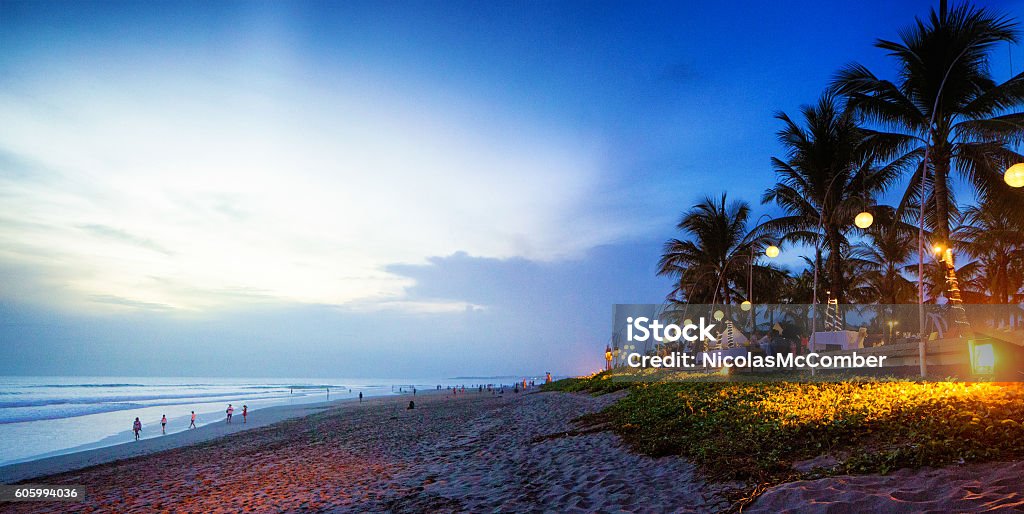 Seminyak Denpasar Bali Indonesia beach scene at sunset Seminyak Denpasar Bali Indonesia beach scene at sunset with a crowd at the left and a beach side restaurant at the right. Bali Stock Photo