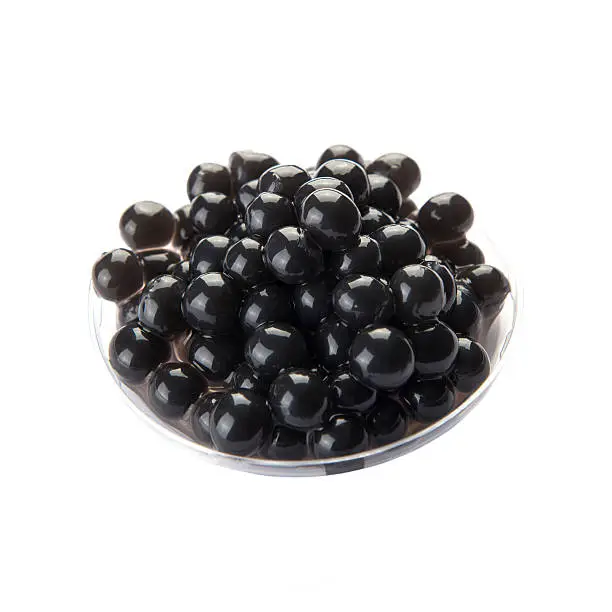 Black bubble tea tapioca pearls in plastic containers isolated on white