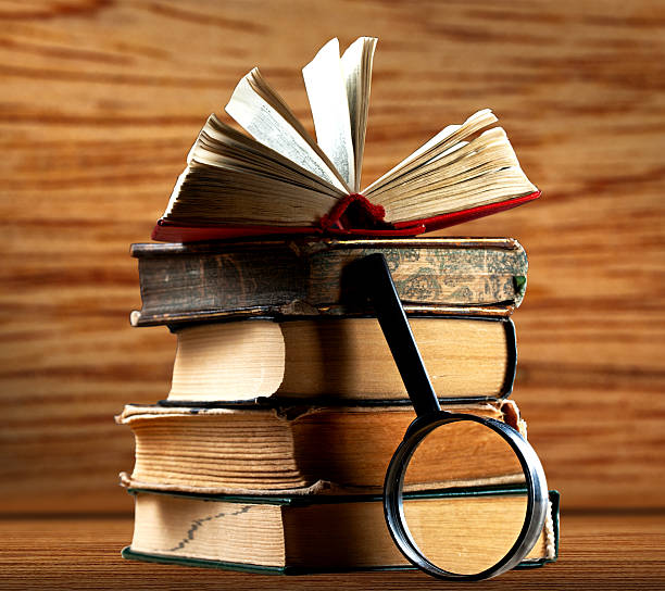 istock Old books with magnifying glass 606001572