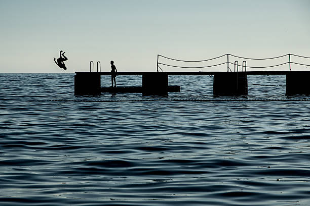 istock Silhouette of a somersault off jetty 606002330