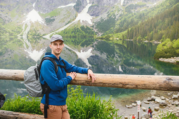 istock man relaxing on the lake and mountains sunny landscape 606005732