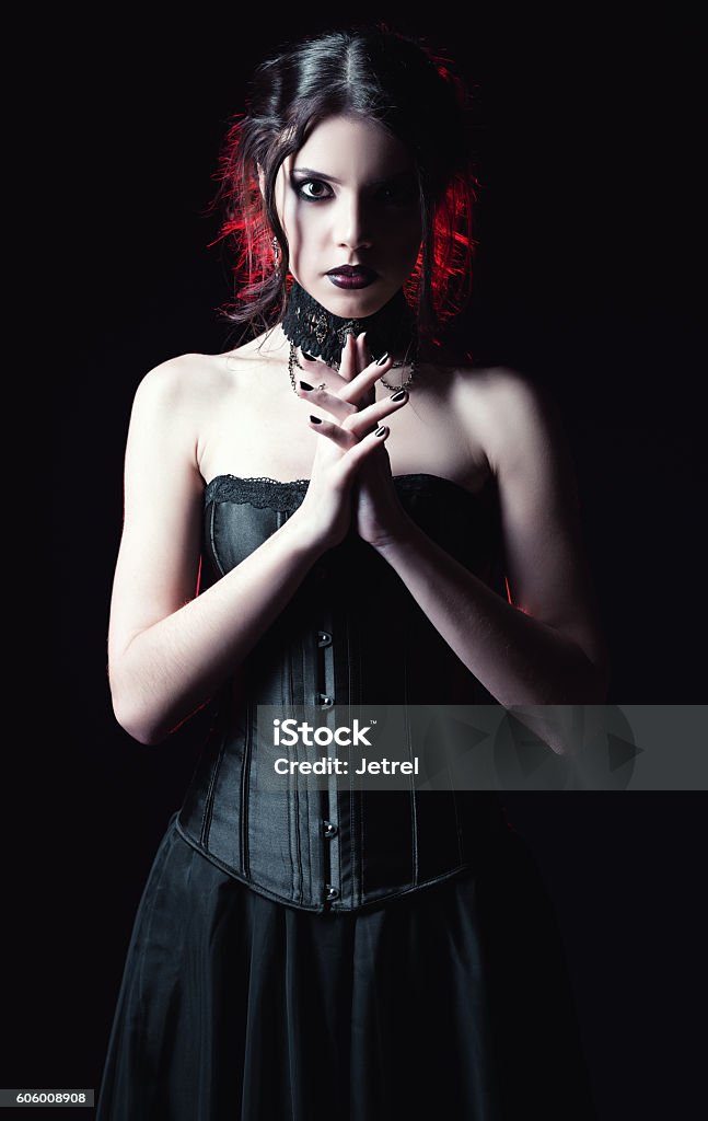 Dramatic portrait of beautiful goth woman among the dark Dramatic portrait of a beautiful goth woman among the dark Goth Stock Photo