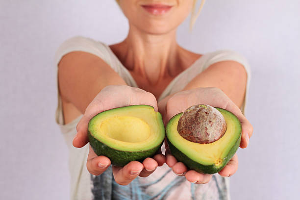 Woman holding avocado closeup.